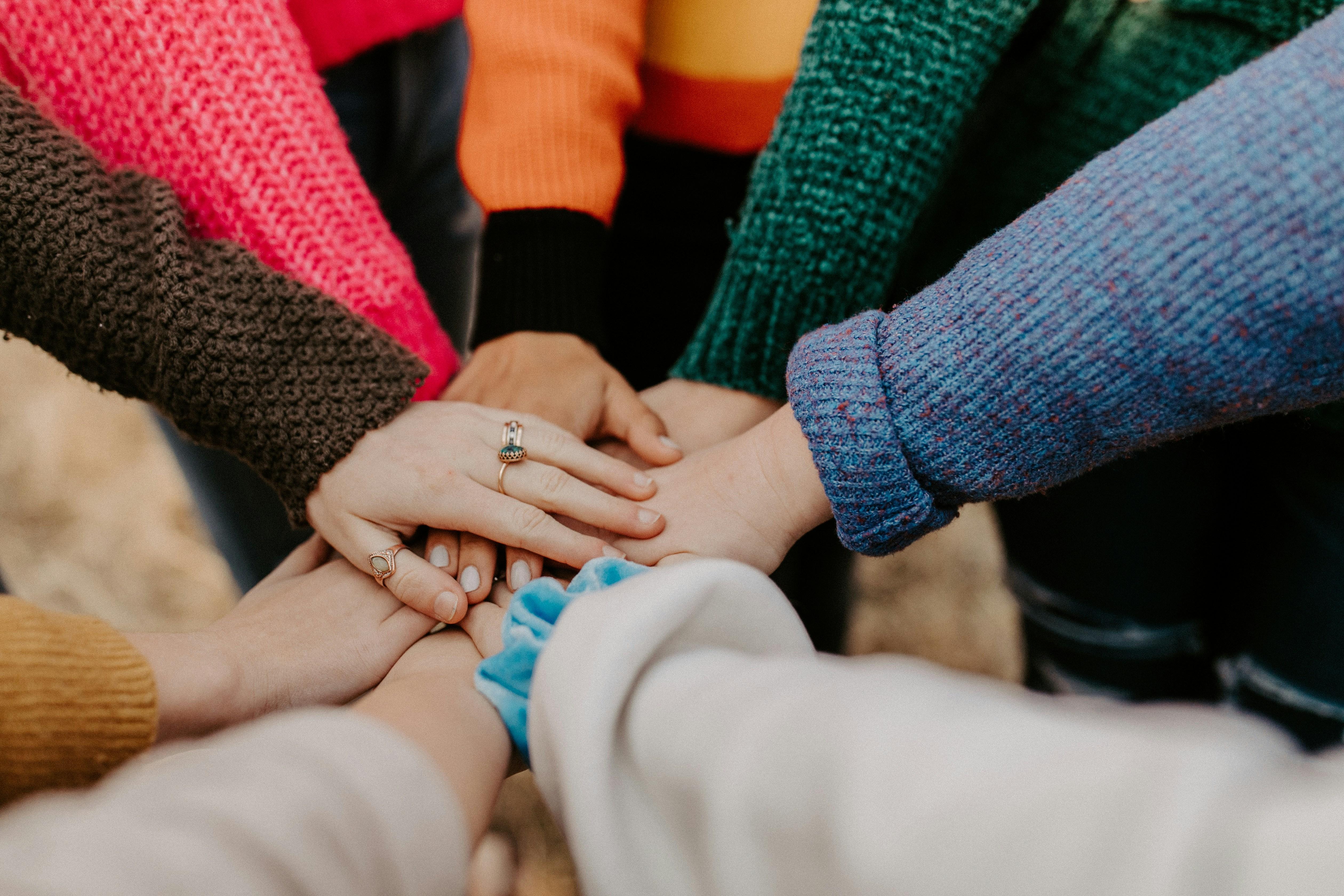 Team members stacking their hands together in a circle